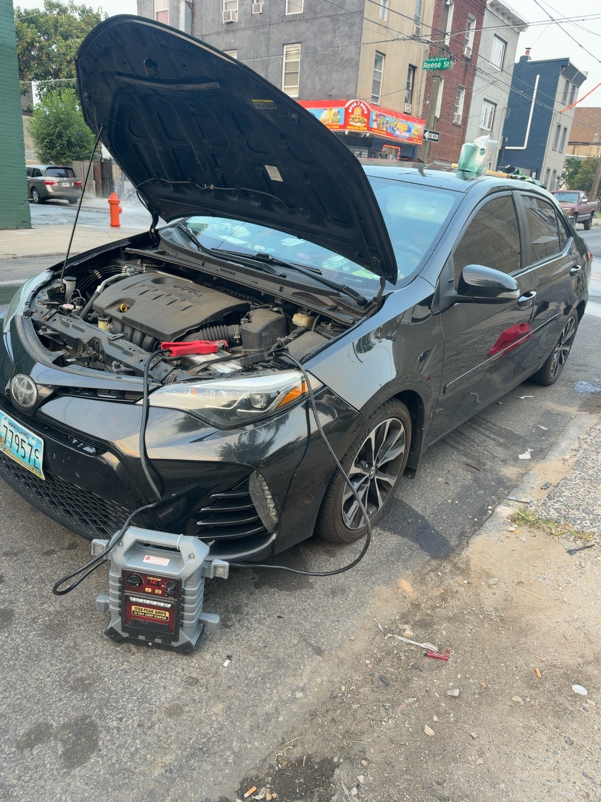 Jump starting a Toyota Corolla on a Philadelphia rowhome street